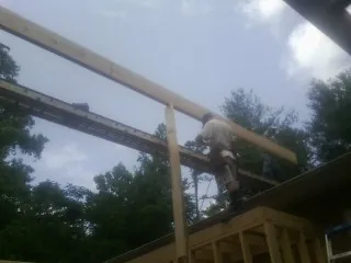 Carpenter setting a ridge beam over a new addition frame — Ice Dam Removal by Roofing Brothers in Metuchen