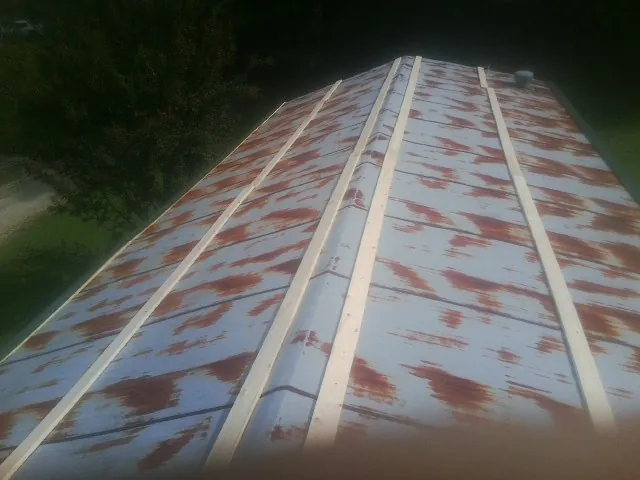Rusted metal roof panels with new wood purlins before replacement — Storm Damage Roof Repair in Metuchen by Roofing Brothers