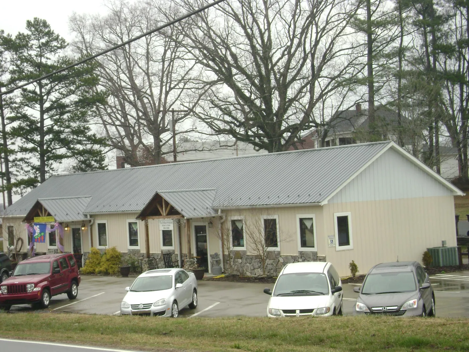 Gray metal roof with timber entry brackets on a small commercial building in Metuchen