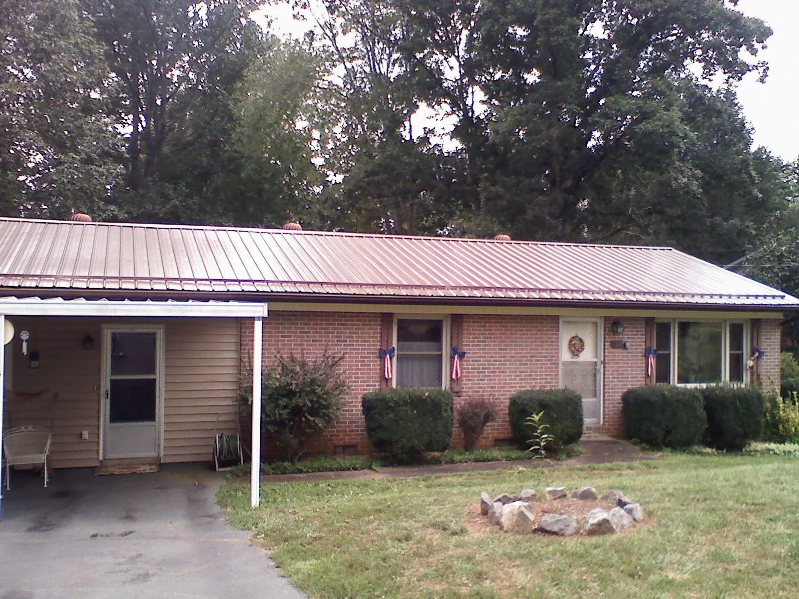Bronze metal roof and carport on a brick ranch home — Roof Repair work by our crew in Metuchen